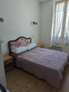 1 dormitorio con 1 cama grande y 2 ventanas en Auberge Des Pins, en Aubenas