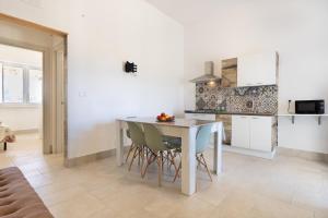Villetta Gioia في توري سودا: مطبخ وغرفة طعام مع طاولة وكراسي