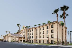 a building with palm trees in front of a street at Holiday Inn Express Hotel & Suites Yuma, an IHG Hotel in Yuma