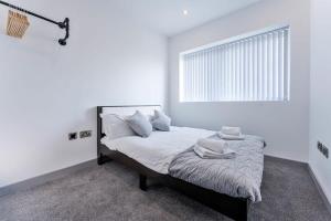 una camera da letto con un letto con pareti bianche e una finestra di Fantastic 1 Bed Apartment in Wolverhampton a Wolverhampton