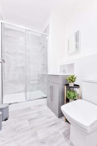 a white bathroom with a shower and a toilet at Fantastic 1 Bed Apartment in Wolverhampton in Wolverhampton