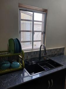 a kitchen counter with a sink and a window at Modern & Cheerful 2 Bedroom Villa, Alagbaka in Akure +37 photos