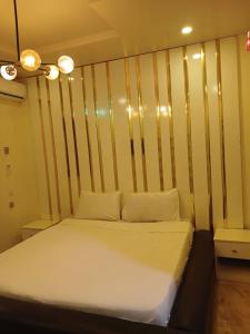 uma cama num quarto com uma parede listrada em Lemmy's Villa - Private vacation home em Akure