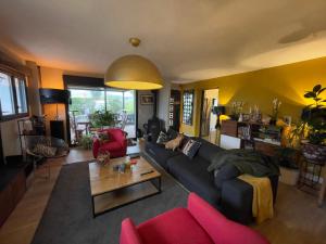 a living room with a couch and a table at Casa Lovo in Saint-Laurent-de-Mure