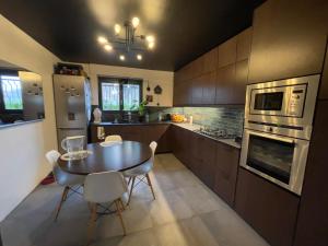 une cuisine avec une table et des chaises. dans l'établissement Casa Lovo, à Saint-Laurent-de-Mure