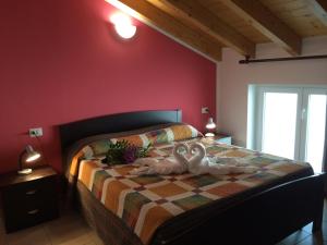 2 cigni seduti su un letto in una camera da letto di Residence Le Azalee & SPA a Vercana
