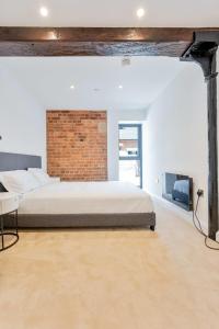 a bedroom with a bed and a brick wall at Characterful 1 Bed Apartment in Burton-on-Trent in Burton upon Trent