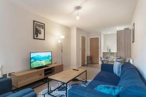 salon z niebieską kanapą i telewizorem w obiekcie Spacious 2 Bed Apartment in Manchester Centre w Manchesterze
