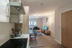 a kitchen and a living room with a table at Spacious 2 Bed Apartment in Manchester Centre in Manchester