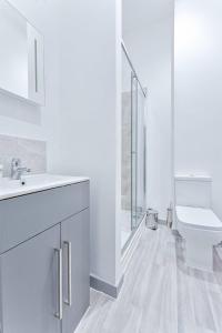 Baño blanco con aseo y lavamanos en Modern and Bright 1 Bed Apartment Dudley, en Brierley Hill