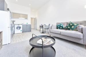 ein Wohnzimmer mit einem Sofa und einem Tisch in der Unterkunft Modern and Bright 1 Bed Apartment Dudley in Brierley Hill