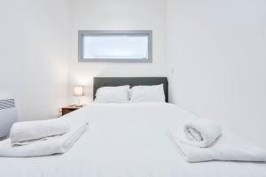 a white bedroom with a bed and a window at Modern and Bright 1 Bed Apartment Dudley in Brierley Hill