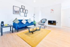 ein Wohnzimmer mit einem blauen Sofa und einem Tisch in der Unterkunft Stunning 1 Bed Apartment in Burton-on-Trent in Burton upon Trent