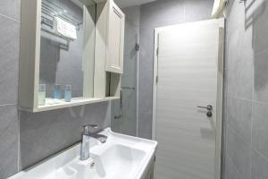 a white bathroom with a sink and a shower at Charming Budget Studio in Central Sunderland in Sunderland