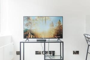 a tv sitting on a stand in a living room at Modern 1 Bedroom Apartment in Preston Centre in Preston