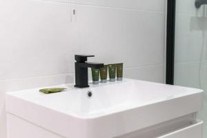 a white bathroom sink with a black faucet at Modern 1 Bedroom Apartment in Preston Centre in Preston