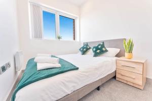 a white bedroom with a large bed and a window at Modern 2 Bedroom Apartment Central Wolverhampton in Wolverhampton