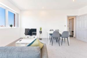 ein Wohnzimmer mit einem Sofa und einem Tisch mit Stühlen in der Unterkunft Modern 2 Bedroom Apartment Central Wolverhampton in Wolverhampton