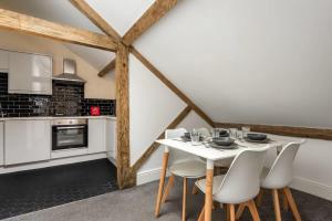 a kitchen and dining room with a white table and chairs at Budget Studio Apartment in Central Doncaster in Doncaster
