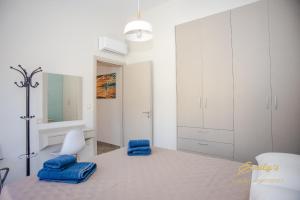 um quarto branco com almofadas azuis numa cama em Emily's Luxury Apartments em Argostólion