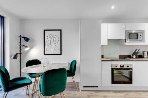 cocina con mesa y sillas verdes en Modern Fabulous Flat In Central Birmingham, en Birmingham