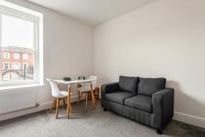 a living room with a couch and a table at Contemporary Budget Studio in Central Doncaster in Doncaster