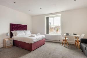 a bedroom with a bed and a table and a window at Contemporary Budget Studio in Central Doncaster in Doncaster