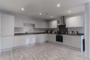 a white kitchen with white cabinets and appliances at Modern 2 Bedroom Apartment in Liverpool in Liverpool