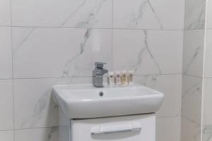 a white sink in a white tiled bathroom at Modern 2 Bedroom Apartment in Liverpool in Liverpool