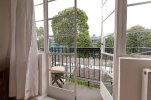 Habitación con ventana con vistas a un balcón. en Bright & Spacious Top Floor Apartment in Chelsea, en Londres
