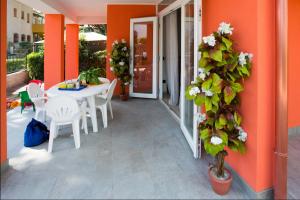 a patio with a white table and chairs and a plant at Principesse in Rosolina Mare