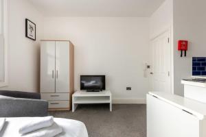 a white living room with a tv and a white cabinet at Modern and Cosy Budget Studio in Central Doncaster in Doncaster