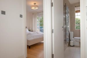 - Baño con 1 dormitorio con 1 cama y aseo en Bright & Spacious Top Floor Apartment in Chelsea, en Londres