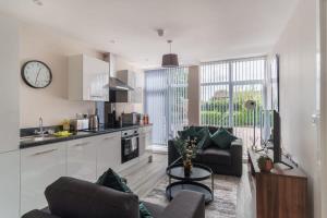 uma cozinha e sala de estar com um sofá e uma mesa em Bright & Modern 1 Bed Apartment in Manchester em Manchester