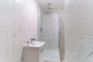 a white bathroom with a shower and a sink at Fantastic 1 Bedroom Apartment in Liverpool in Liverpool