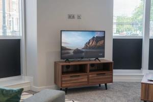 a flat screen tv sitting on a wooden stand in a living room at Fantastic 1 Bedroom Apartment in Liverpool in Liverpool