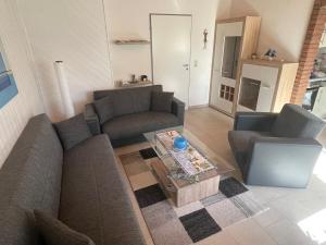 a living room with two couches and a coffee table at Ferienhaus Gomann in Dornum