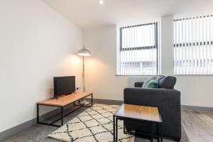 a living room with a couch and a tv at Lovely Studio Apartment in Central Wakefield in Wakefield