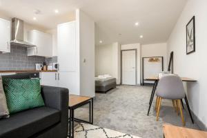 a living room with a couch and a table at Lovely Studio Apartment in Central Wakefield in Wakefield