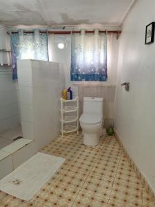 a bathroom with a toilet and a shower at Nick's and Essy's place in Juja