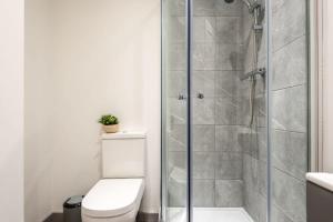 a bathroom with a toilet and a glass shower at Modern Budget Apartment in Central Doncaster in Doncaster