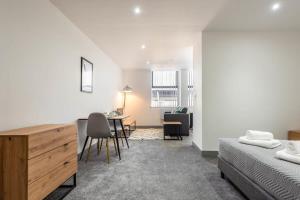 a bedroom with a bed and a desk and a table at Lovely Studio Apartment in Central Wakefield in Wakefield