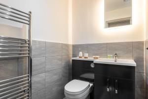 a bathroom with a toilet and a sink at Lovely Studio Apartment in Central Wakefield in Wakefield