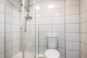 a white bathroom with a shower and a toilet at Bright 1 Bedroom Budget Flat in Central Pontefract in Pontefract