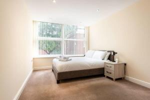 a bedroom with a bed and a large window at Bright 1 Bedroom Budget Flat in Central Pontefract in Pontefract