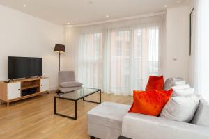 a living room with a white couch and a television at Modern 2 Bed Apartment in South Lambeth in London