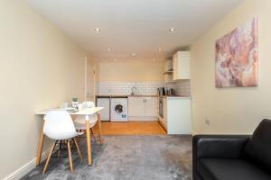 a kitchen and living room with a table and chairs at Bright 1 Bedroom Budget Flat in Central Pontefract in Pontefract