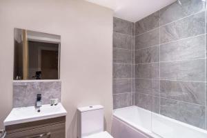 uma casa de banho com uma banheira, um WC e um lavatório. em Contemporary 1 Bed Manchester Apartment em Manchester