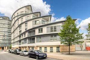 a large white building with cars parked in front of it at Stylish 1 Bedroom Apartment in Central Woking in Woking