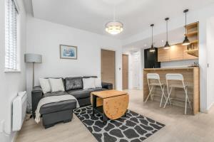 ein Wohnzimmer mit einem Sofa und einem Tisch in der Unterkunft Stylish 1 Bedroom Apartment in Central Woking in Woking
